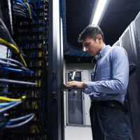 Data center specialist inspecting a data center rack.