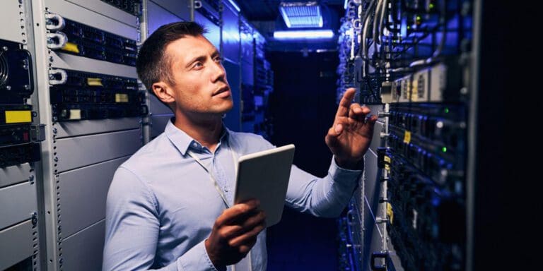 Colocation specialist examining a data center rack.||Person typing a calculator