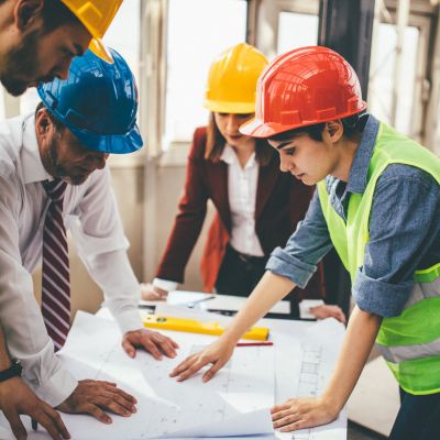 construction workers and executives looking over building plans on a building site